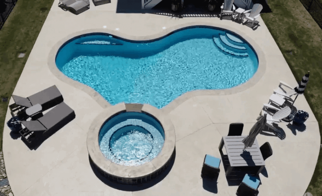 Overhead shot of irregularly shaped pool with attached hot tub
