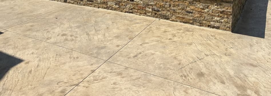 Concrete pool deck stamped with large beige flagstones.